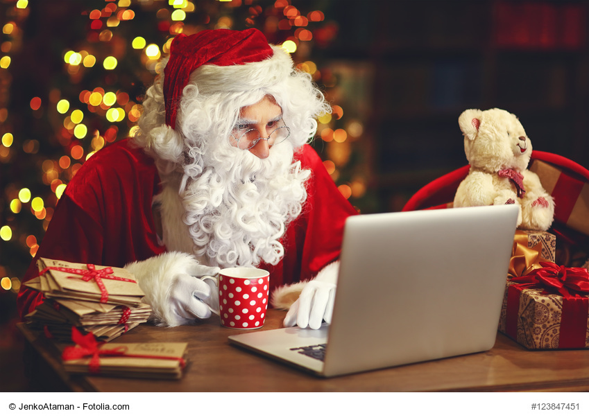 Christmas. Santa Claus with a laptop reading a letter and drinking tea